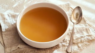 Bone broth in bowl on fabric