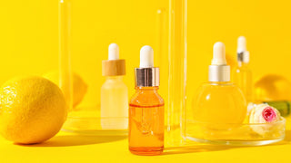 Bottles of Vitamin C Serum on Yellow Background