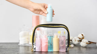 Female Hand and Travel Cosmetics Kit on Table