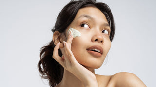 Girl applying skincare cream on face