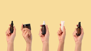 Hands Holding Assorted Skincare Products Routine