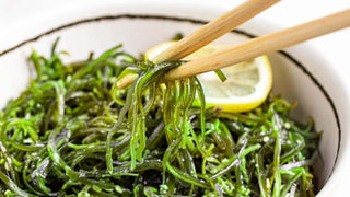 Mekabu in seaweed salad picked up by chopsticks