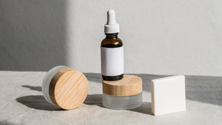 Skin care serum bottle with cleansing bar on fabric surface
