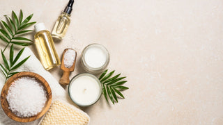 Skincare products laid on surface with towel and leaves