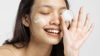 Smiling Woman with Facial Moisturizer Holding a Cosmetic Container