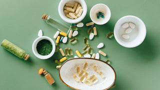 Variety of collagen supplements pills powder on green background in bowls