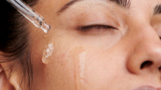 Woman applying clear serum on face