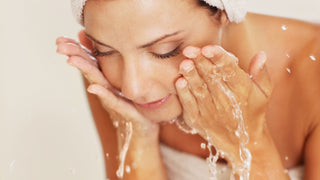 Woman washing face with towel wrapped