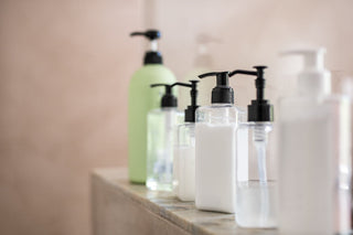 Dispenser bottles in a row kept on rack in bathroom