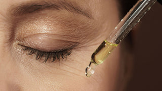 female eye and dropper with serum