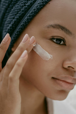 Woman Putting Face Cream on Cheek